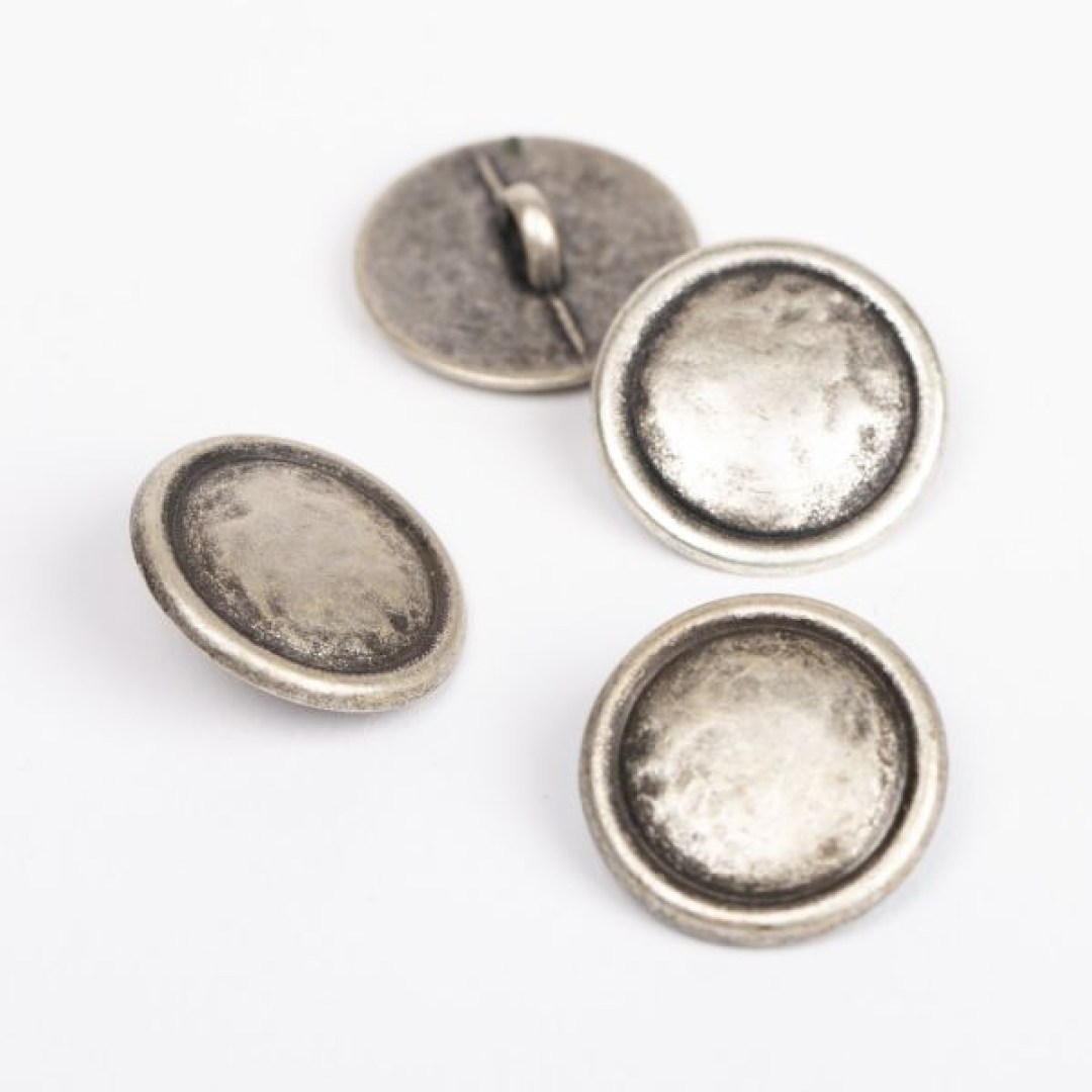 Μεταλλικό κουμπί DROPS Loop Silver 20 mm με ποδαράκι, σε απόχρωση ασημιού. Κομψό και ανθεκτικό, ιδανικό για ζακέτες, παλτό και αξεσουάρ.
