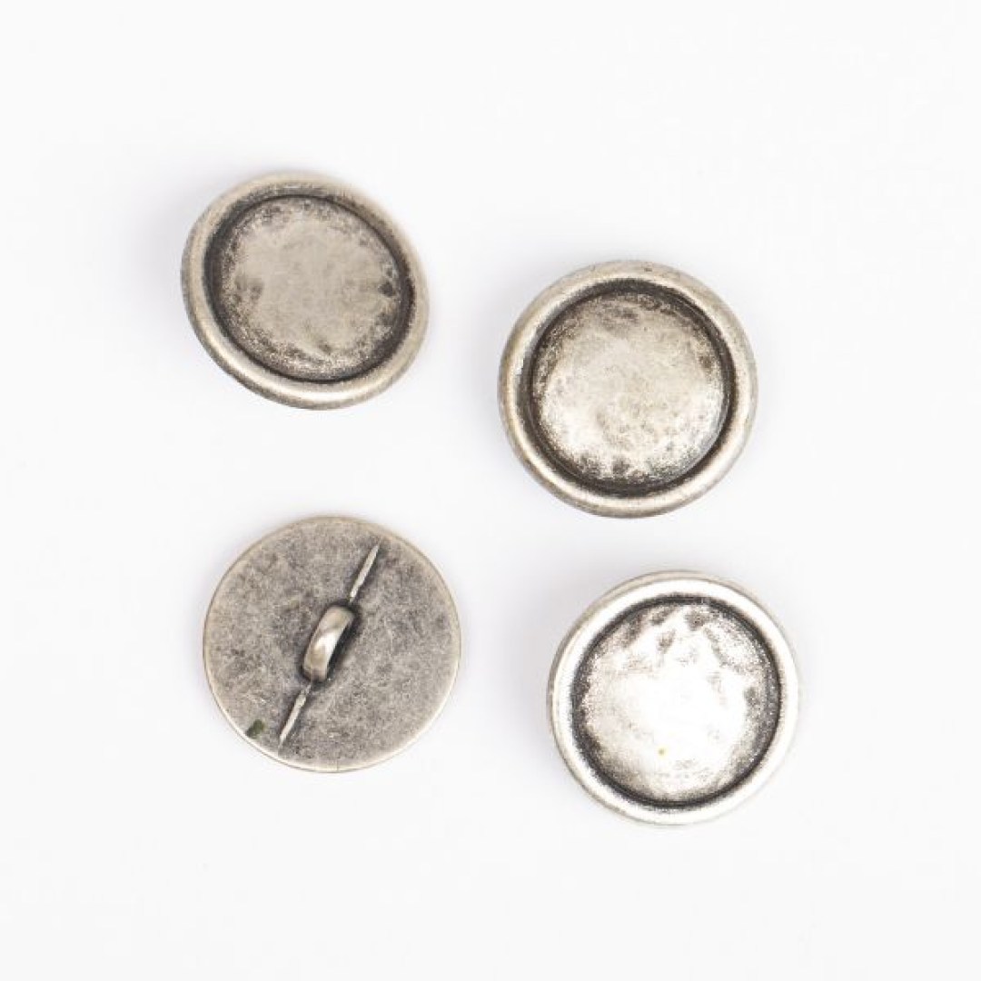 Μεταλλικό κουμπί DROPS Loop Silver 20 mm με ποδαράκι, σε απόχρωση ασημιού. Κομψό και ανθεκτικό, ιδανικό για ζακέτες, παλτό και αξεσουάρ.