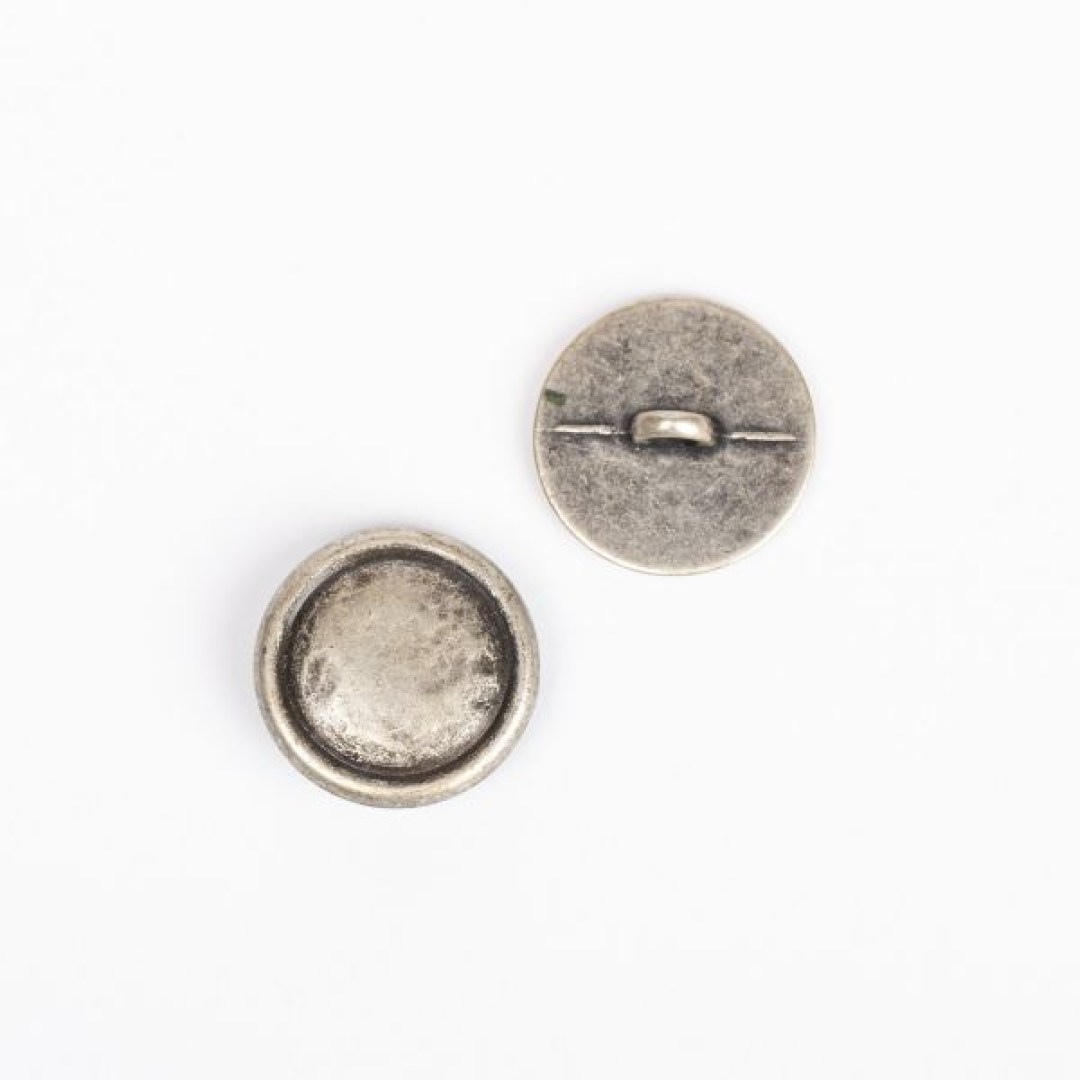 Μεταλλικό κουμπί DROPS Loop Silver 20 mm με ποδαράκι, σε απόχρωση ασημιού. Κομψό και ανθεκτικό, ιδανικό για ζακέτες, παλτό και αξεσουάρ.