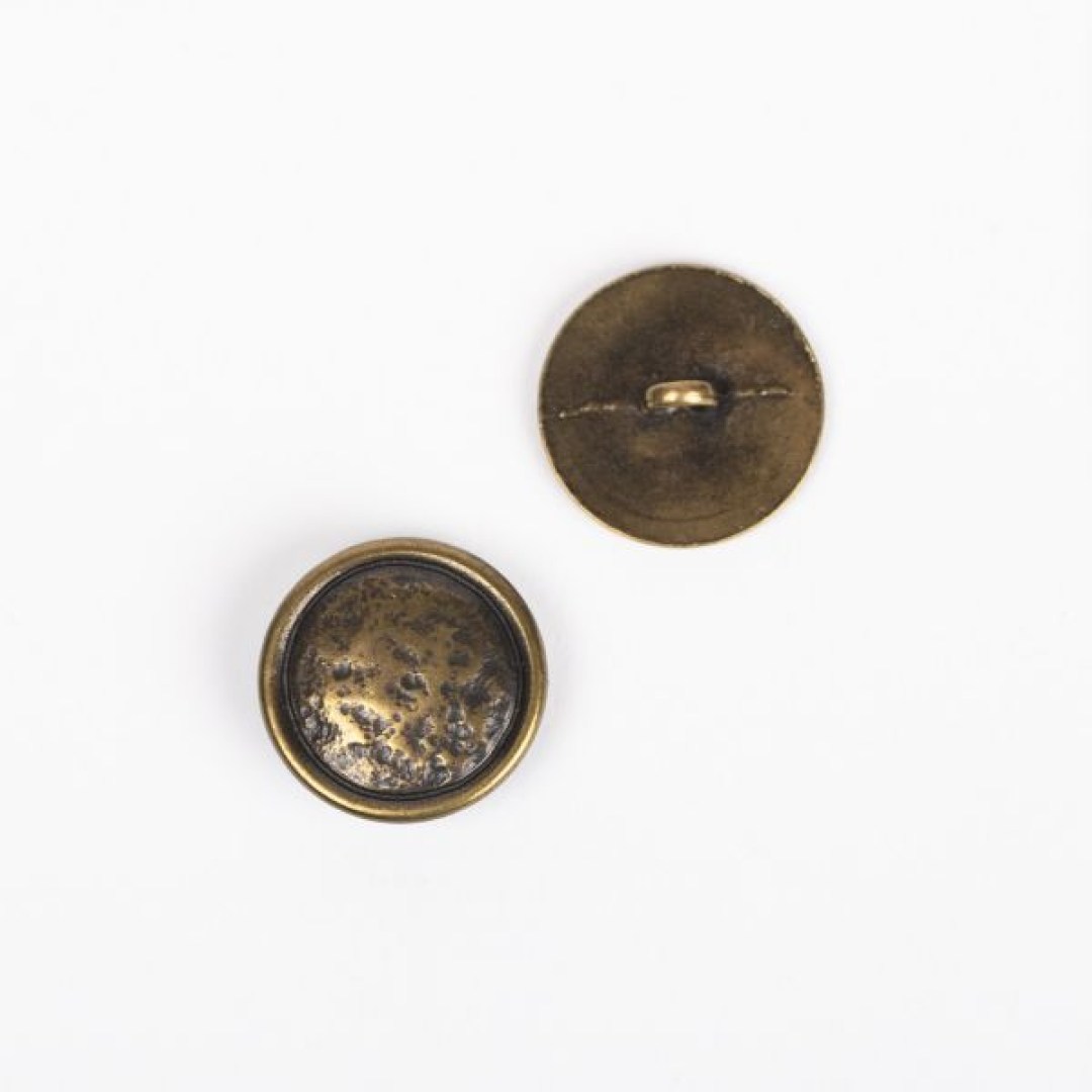 Μεταλλικό κουμπί DROPS Loop Brass 20 mm με ποδαράκι, σε απόχρωση χαλκού. Ανθεκτικό και κομψό, ιδανικό για ζακέτες, παλτό και πλεκτά projects.